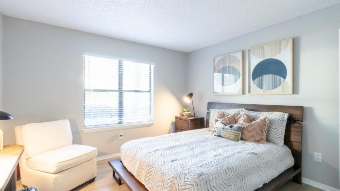 a bedroom with a bed, chair and nightstand at The  Rowen